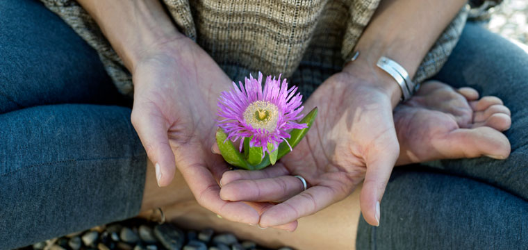Woman holding a flower in her hands by Elena Ray